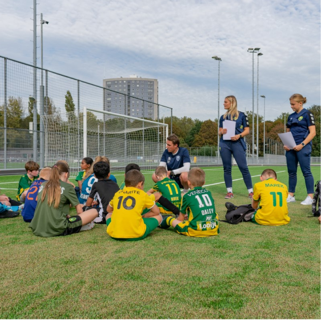 Kinderen die zitten op een voetbalveld